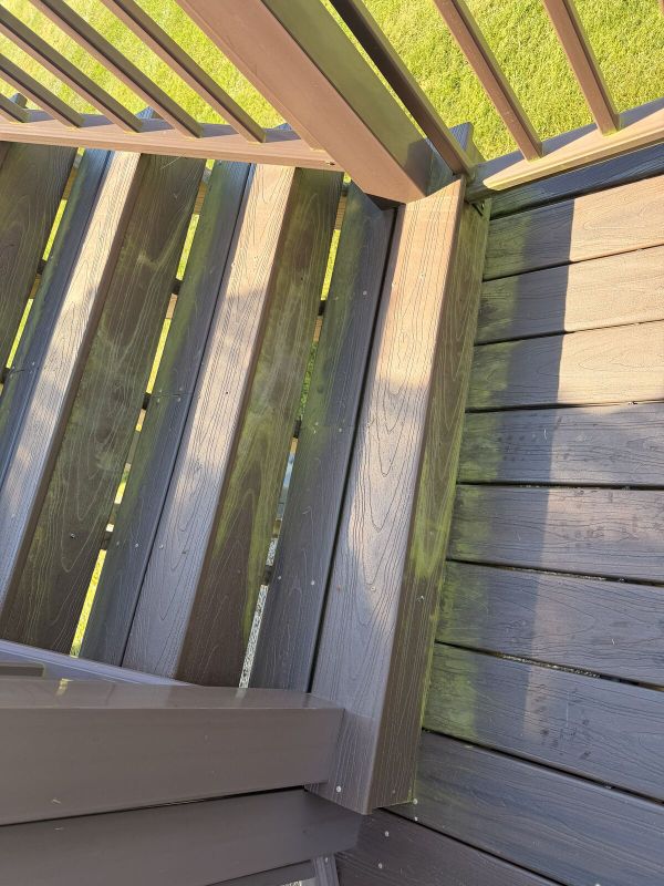 Wooden deck stairs covered in green algae and grime before pressure washing