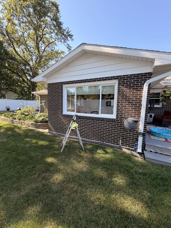 Professional exterior window cleaning in progress on a brick home