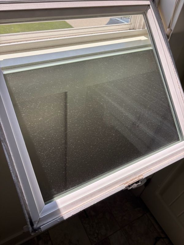 Window glass covered with dirt and spotting before professional cleaning